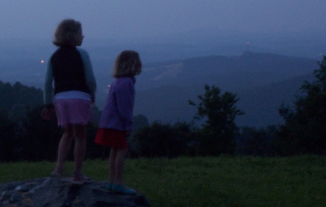 My two oldest girls, so very young then, standing the the dusk looking across a green field at the deepening blue mountains. Photo by my father.