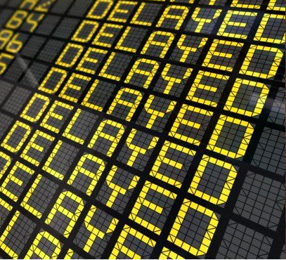 airport flight departure board showing a series of delayed flights