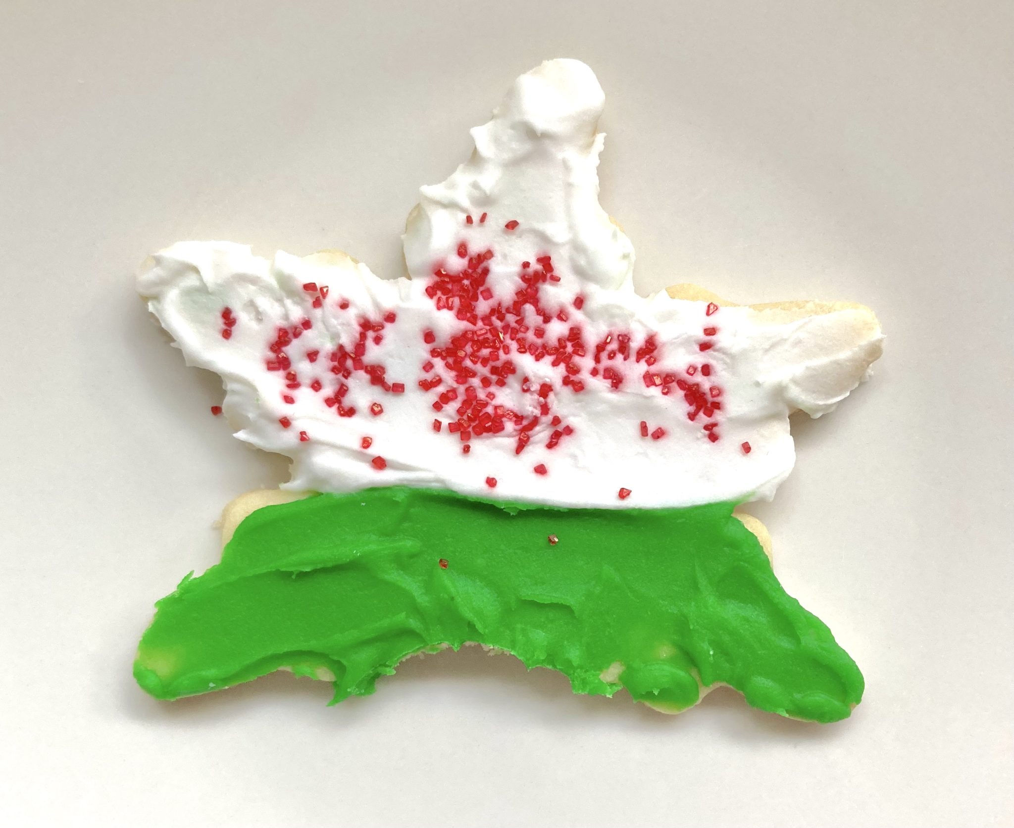 A partially eaten star-shaped sugar cookie decorated